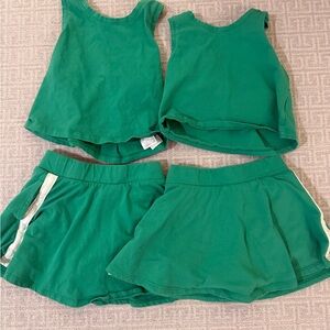 two green athletic tops and two matching skorts